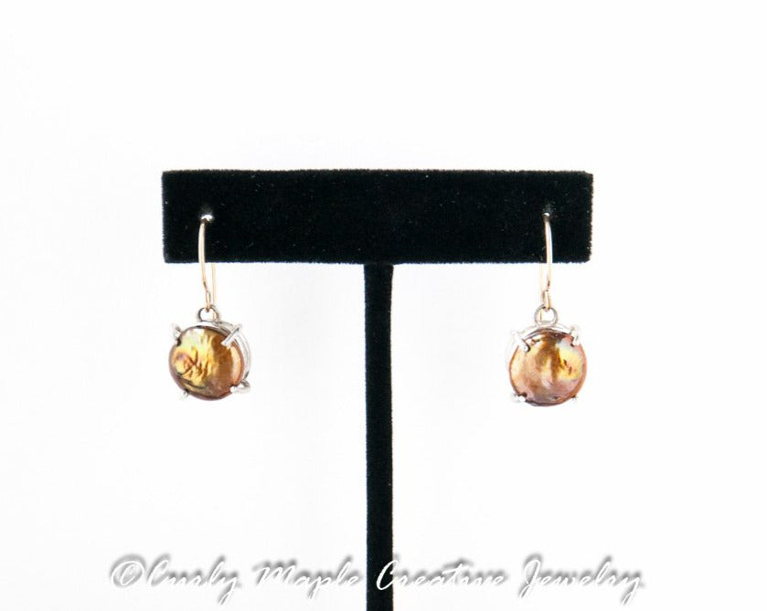 Copper Pearl Silver Dangle Earrings hanging from a jewelry stand