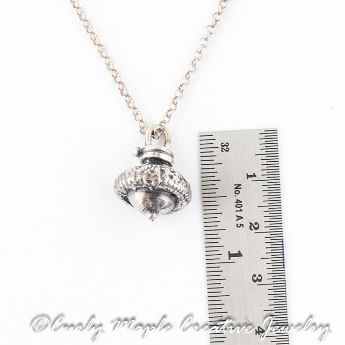 Silver Baby Acorn Pendant with a ruler for scale