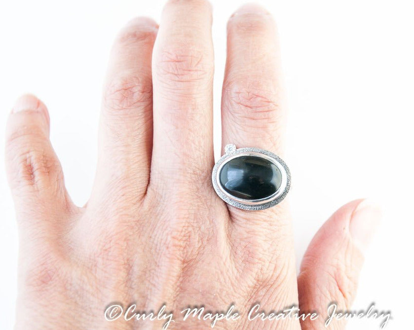 Black Onyx Silver Statement Ring on a woman's index finger
