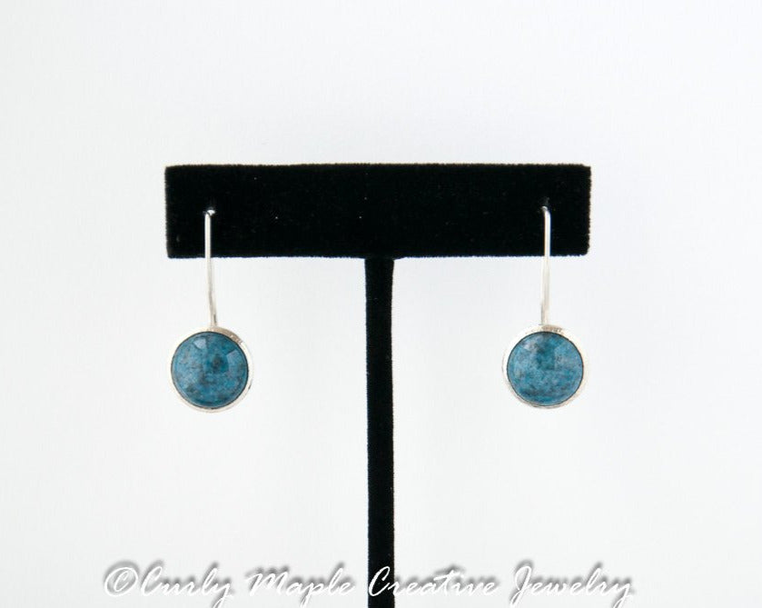 Denim Lapis Silver Dome Earrings hanging from a jewelry stand