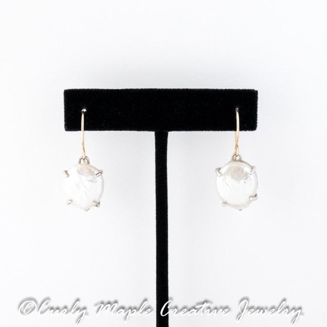 White Pearl Silver Drop Earrings hanging from an earring stand